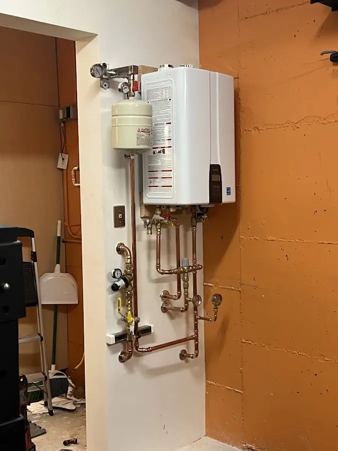 Plumbing technician inspecting water heater connections in Naperville